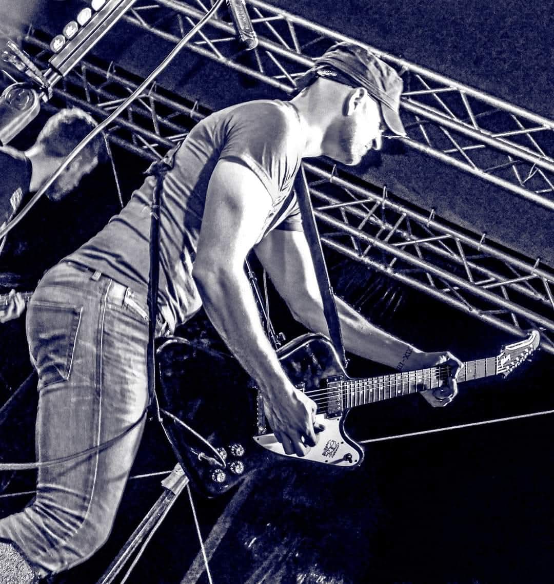 Greg Warren Band guitarist performing on stage in an artistic black and white photo